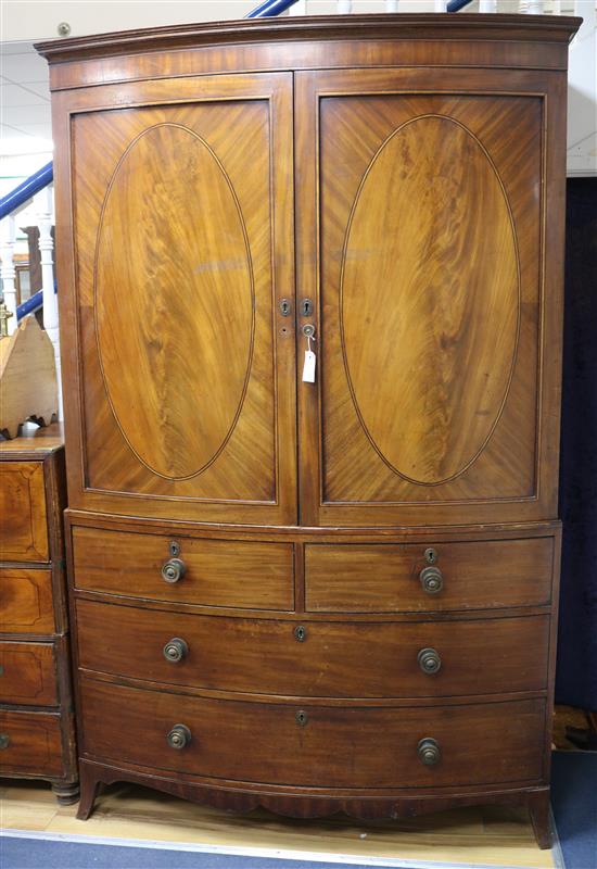 A Regency mahogany bow fronted linen press, with two doors enclosing five sliding trays over two short and two long drawers W.133cm